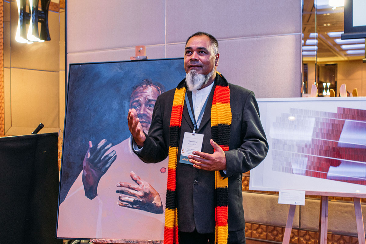 Shaun Nannup posing with his portrait.